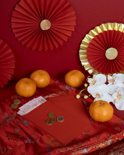 幸运的中国新年庆祝与橙色红色的红包、旗袍和东方兰花花在红色的背景