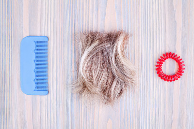 Blond hair lock, red scrunchie, blue plastic comb 