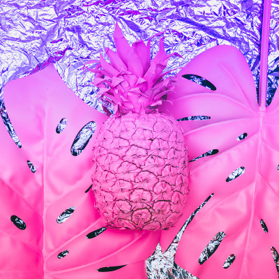 菠萝上带有热带棕榈叶的全息金属箔