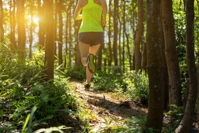 年轻女子trail runner在日出热带森林跑步