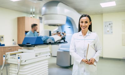 癌症治疗在现代医疗私人诊所或医院用直线加速器。在这名妇女接受癌症放射治疗时，专业的医生团队正在工作