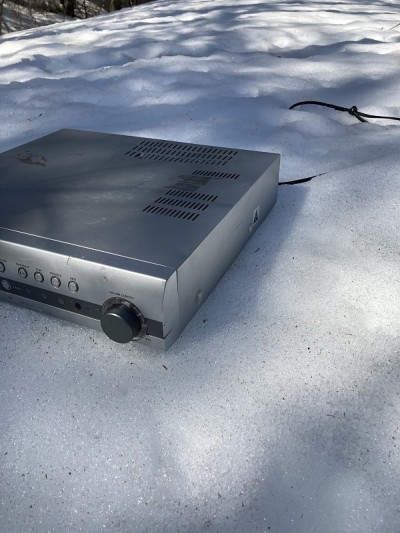 丢弃的DVD播放器在雪地里。