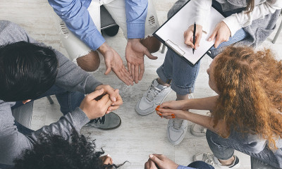 不同的人在小组治疗中分享他们的问题，俯视图