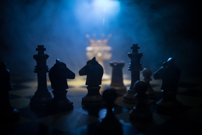 棋牌游戏的经营理念和竞争理念以及战略理念。象棋人物在黑暗的背景与烟和雾和窗户与阳光。有选择性的重点