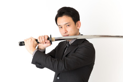 亚洲商人的肖像使用武士刀孤立在白色的背景