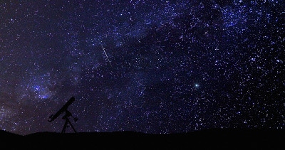 望远镜的剪影和星空下的乡村。