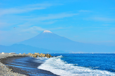 从日本新三大风景名胜区之一的静冈县松原美穗山观赏富士山，海浪拍打着海岸。