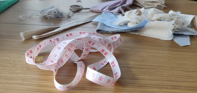 Self-sewing防护面具。桌上放自制的防护口罩和几块布