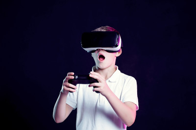 男孩戴着VR眼镜玩游戏手柄