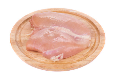 放在砧板上的生鸡胸肉。