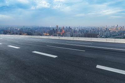 空旷的高速公路与城市景观和天际线，中国重庆。