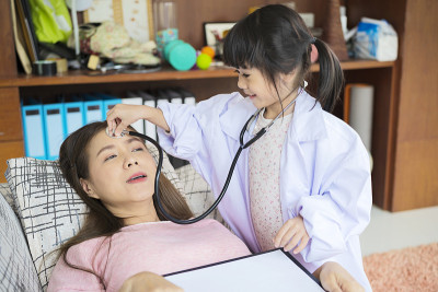可爱的亚洲小女孩扮演护士拿着听诊器听妈妈