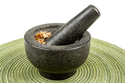 臼和杵与干山金车树叶在布背景