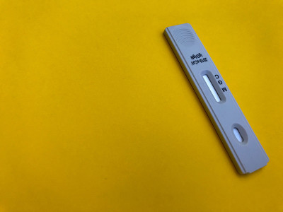 医疗程序。亮黄色背景上的冠状病毒测试。新的家庭自我诊断工具包。敏感试纸条采血和确定抗体