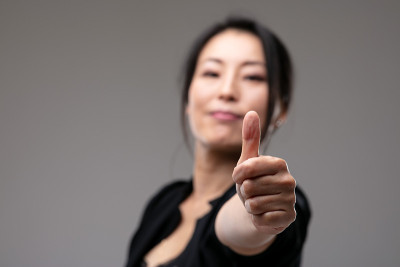 得意洋洋的亚洲女人竖起大拇指