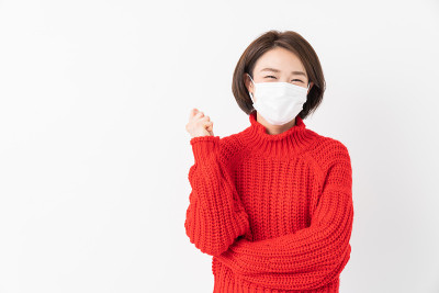 迷人的亚洲女人戴着面具，微笑