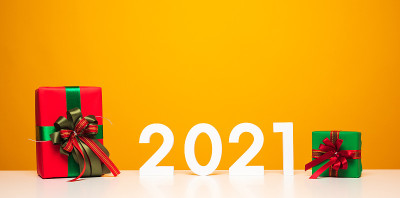 圣诞快乐，新年快乐2021白色桌子和黄色背景与礼物盒模型。庆祝与新年模板和空白背景广告。