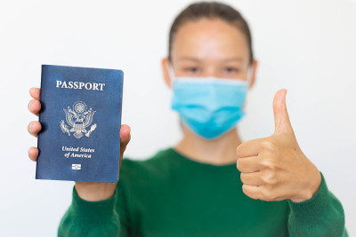 一名持有美国护照并带着口罩旅行的女子。
