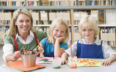 幼儿园老师在美术课上和学生坐在一起