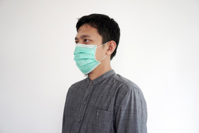 亚洲男子戴口罩预防Covid - 19或冠状病毒