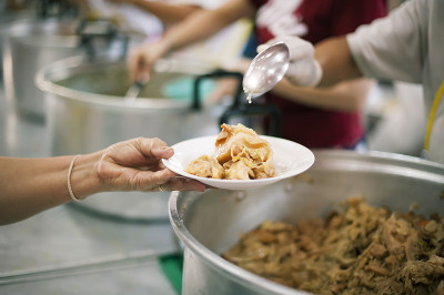 人们从志愿者那里捐赠食物:概念上的乞丐