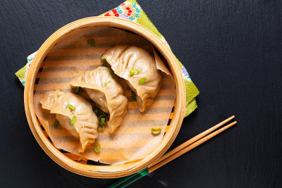 食物概念自制饺子中国饺子竹篓在黑色背景与复制空间