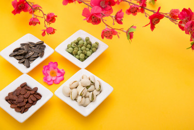 春节，农历新年，中国新年的概念。晒干的葵花子、莲子、西瓜和南瓜子被孤立在黄色的俯视图上