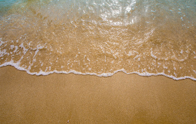 海滩上白色的海浪泡沫