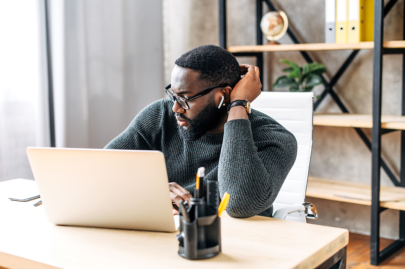 An African-American guy using laptop in the office