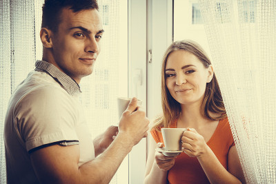 年轻夫妇在家里喝茶或喝咖啡