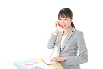 年轻的女商人在办公室使用商务电话