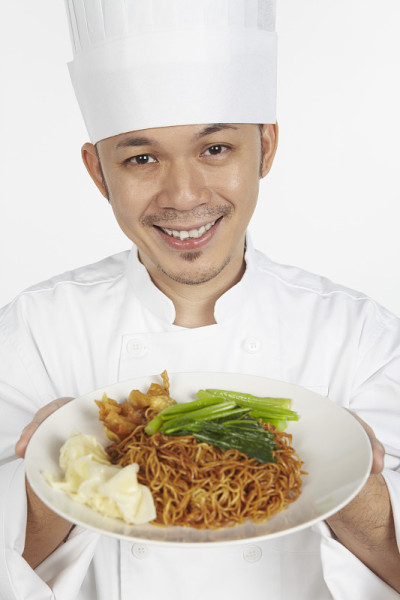 亚洲厨师拿着一盘馄饨面