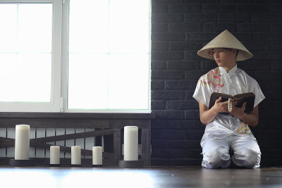 穿着和服的亚洲男孩在读一本旧书
