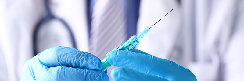 医生手臂戴防护蓝手套准备注射器