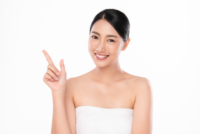 美丽年轻的亚洲女性与干净的新鲜皮肤在白色的背景，面部护理，面部治疗，美容和水疗中心，亚洲女性肖像。