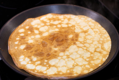 煎锅里的煎饼。厨师准备自制薄饼