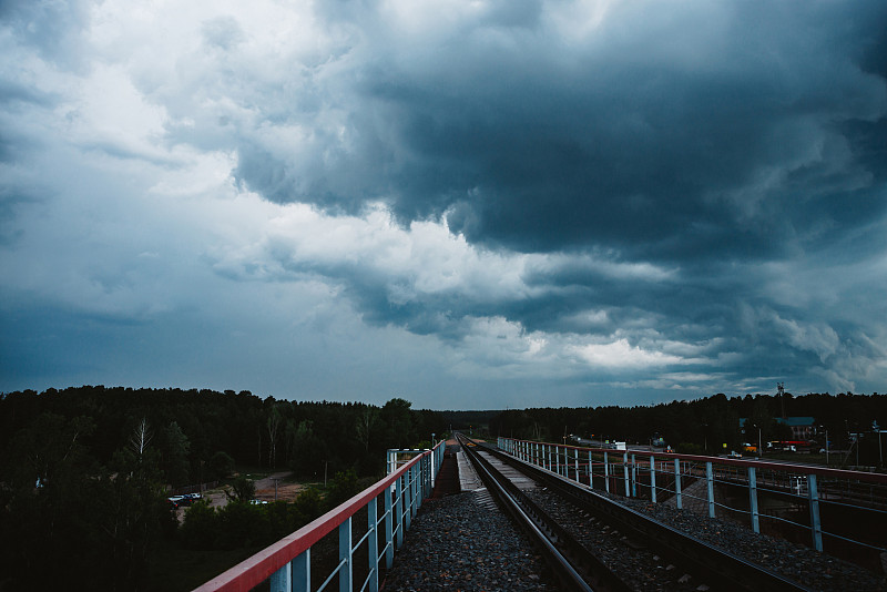 戏剧性的cloudscape。雨前乌云密布。阴雨绵绵的坏天气。风暴警告。铁路上方的自然蓝色积雨云背景