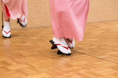 日本妇女的腿和脚在传统舞蹈中穿着完整的传统服装和日本风格的geta鞋，显示了不同寻常的风格站立和舞蹈