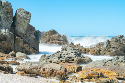 长时间暴露在阳光下的海浪冲刷着布满岩石的前海岸。