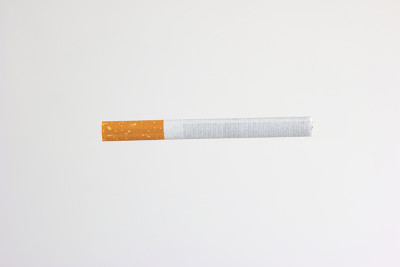 单根未点燃的香烟与黄色滤镜工作室近距离拍摄孤立的白色