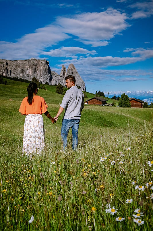 一对男人和女人在意大利Dolomites,Alpe di Siusi - Seiser Alm与Sa