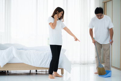 一对亚洲老夫妇正在打扫卧室地板。