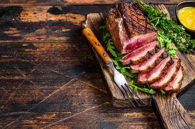 扒鸭脯肉片。深色木制背景。前视图。本空间