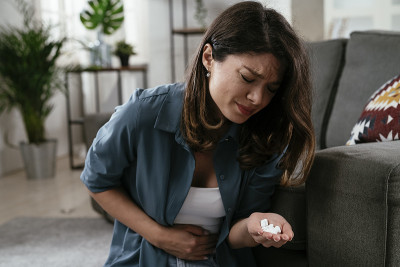 一个伤心不开心的沮丧女人手里拿着一颗药丸。