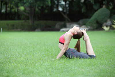 年轻女子练习瑜伽，eka pada Rajakapotasana (King Pigeo)