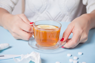 拿着一杯柠檬茶的女人。健康与传统医学概念