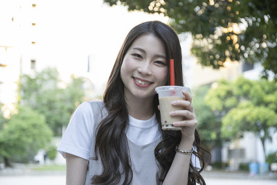 在公园喝木薯饮料的女人