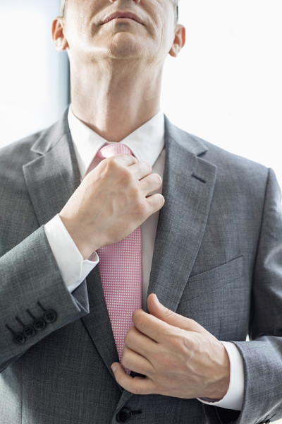 成熟商人正调整领带中部