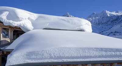 被大雪覆盖的房屋或旅馆的屋顶。高山和冬季的比赛。意大利阿尔卑斯山