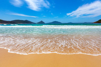 阳光明媚的夏日，海浪冲刷着美丽的海滩